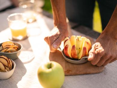 Frisch aufgeschnittener Apfel, Apfelsaft und Apfelchips auf einem Tisch.