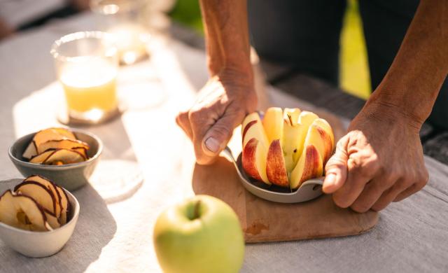 Frisch aufgeschnittener Apfel, Apfelsaft und Apfelchips auf einem Tisch.