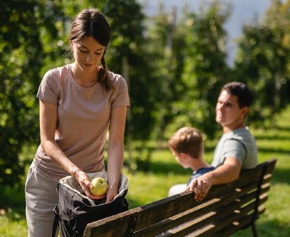 Familie hat Südtiroler Äpfel während ihres Spaziergangs im Rucksack mit dabei.